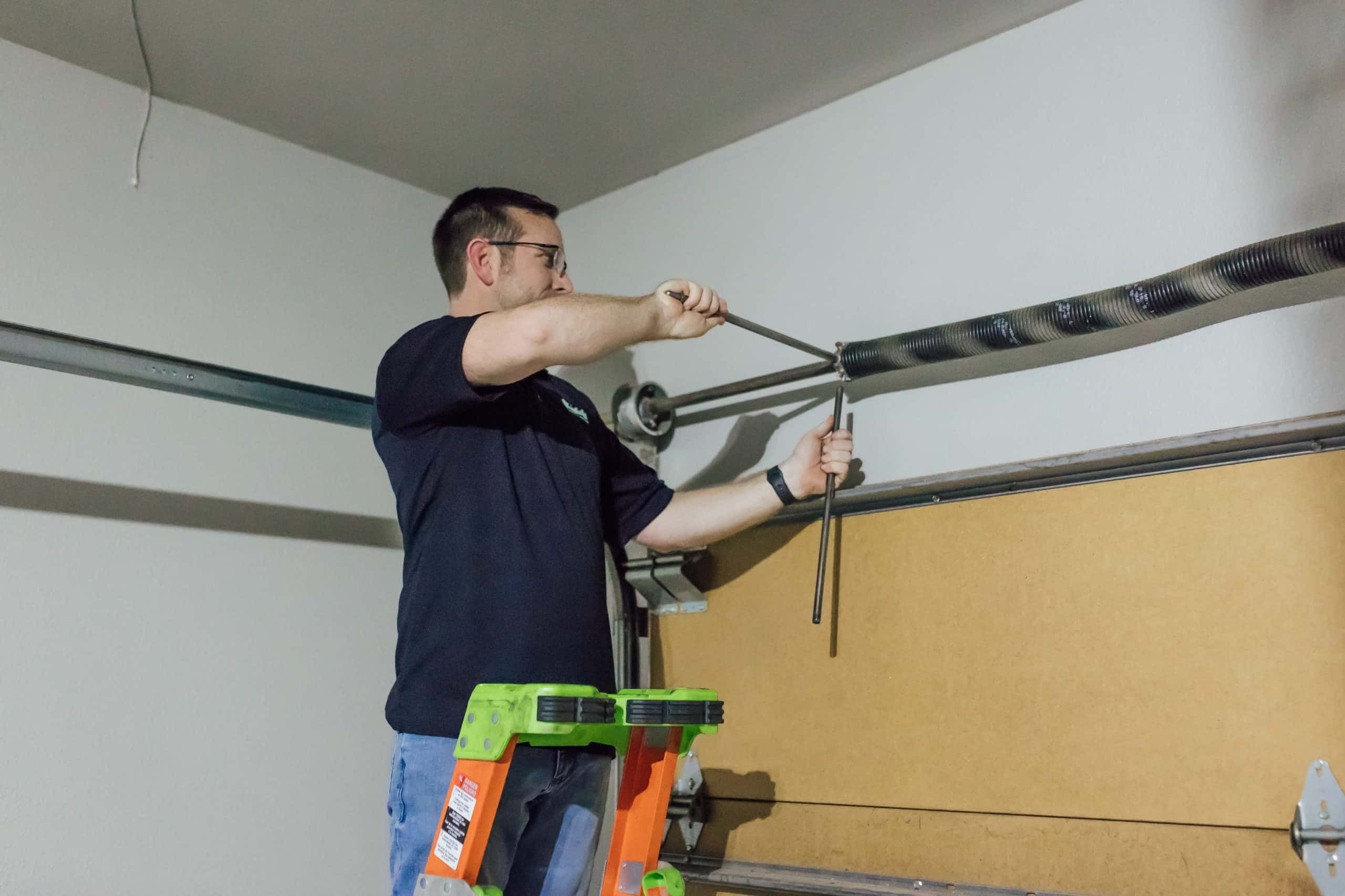 Technician repairing garage door spring
